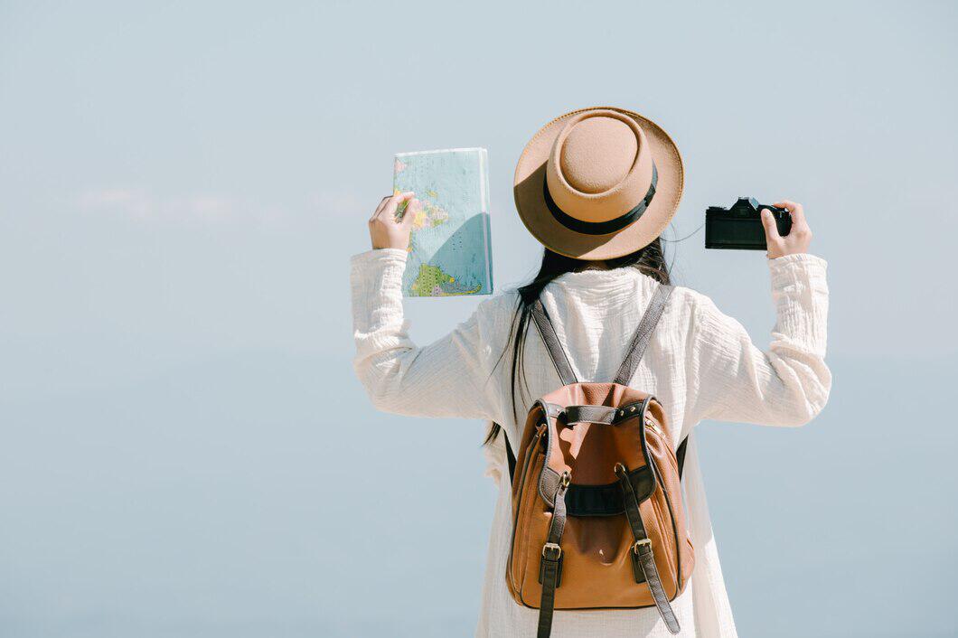 voyageuse de dos tenant une carte et un appareil photo