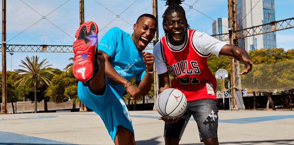 Footasylum deals page image showing 2 guys goofing around while palying basketball. One of the men has a sneaker raised high
