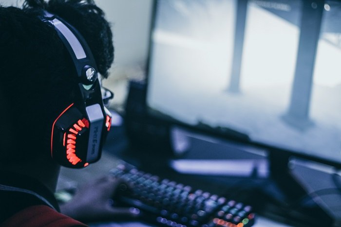 Mann mit Gaming Headset spielt Videospiele am PC