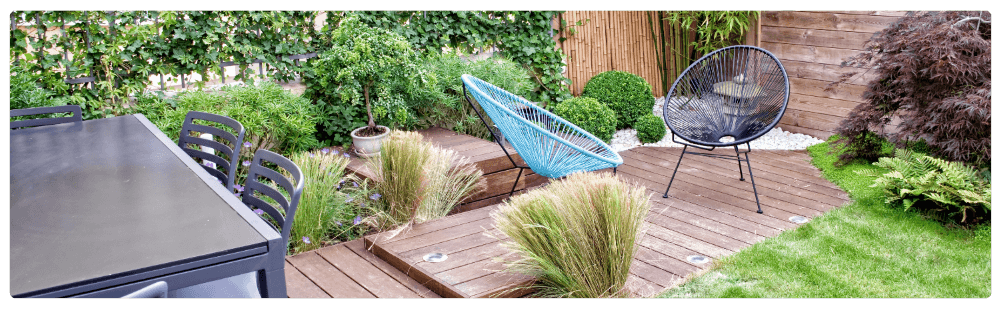 Garden decking image showing wooden decking in a garden setting with chairs, creating a patio area