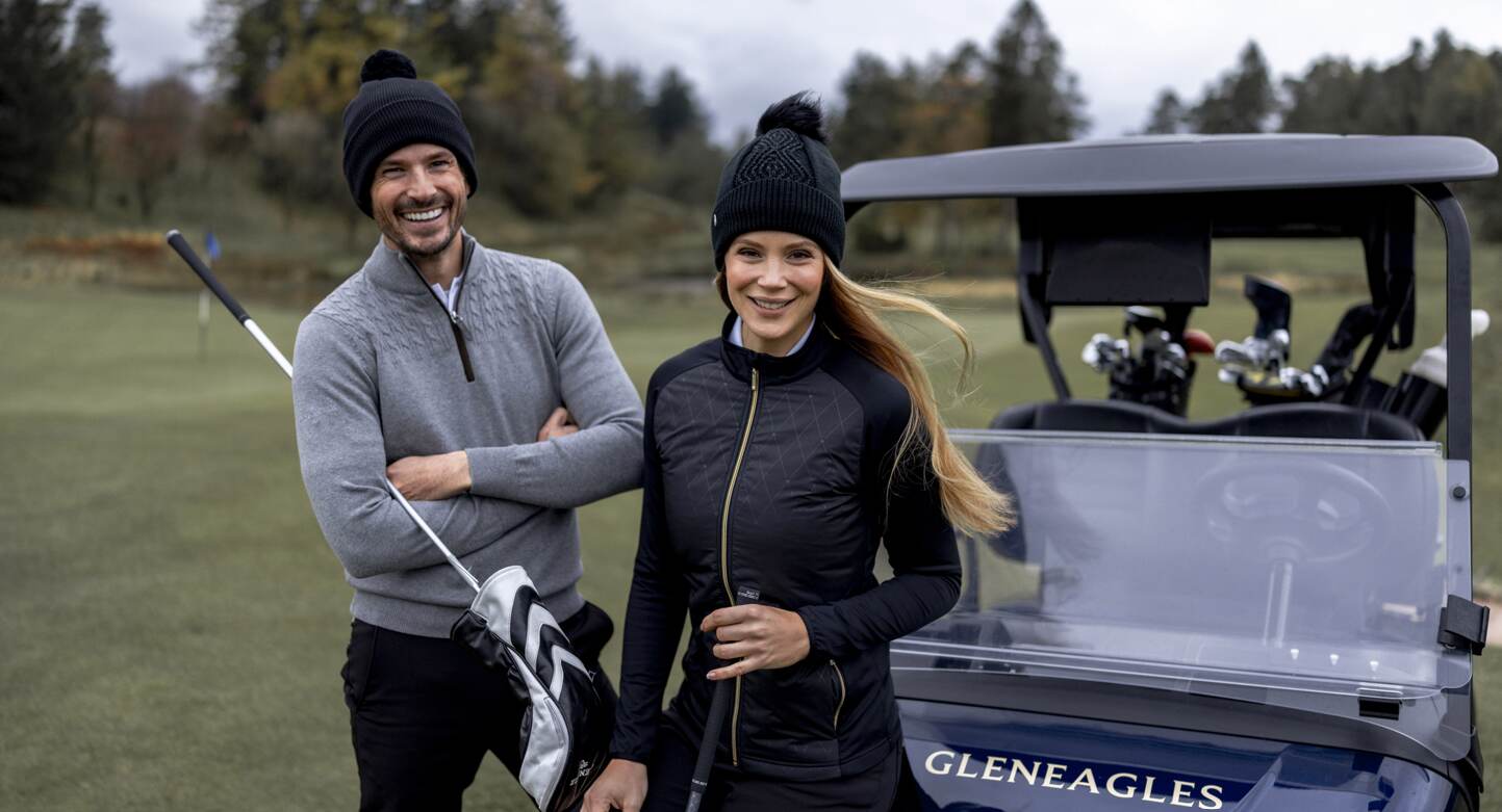 Glenmuir deals page image showing a man and woman holding golf gear on a course, next to a golf buggy that has the name Gleneagles printed on the front