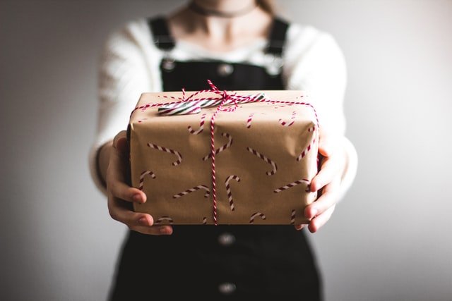 Femme tenant un paquet cadeau pour Noël