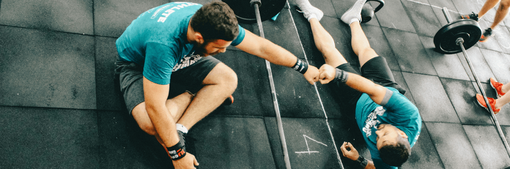 two men fist pumping after a workout