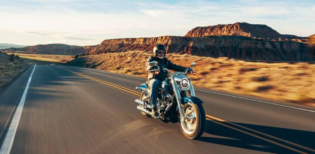 Harley-Davidson how to save banner showing a man in leathers on a motorbike driving down a country road in America