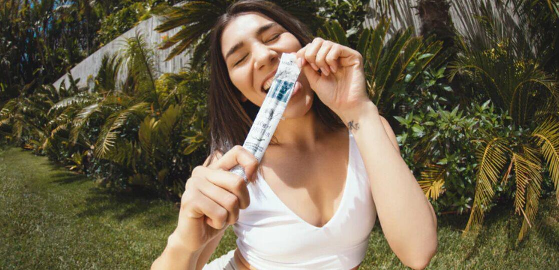Healf savings tips banner - Women with a protein stick in a park