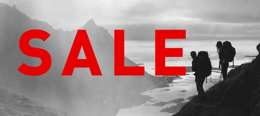 Schwarz-weiß-Aufnahme von Wanderern auf Berg und rote Aufschrift "Sale" als Banner für den Helly Hansen Sale
