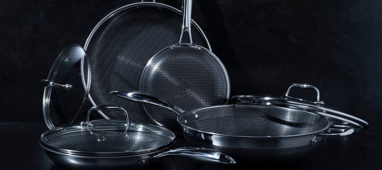 Hexclad offers page banner - A selection of branded pots and pans on a dark background