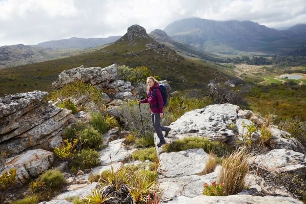 Woman hiking on a mountain in hiking clothing from Mountain Warehouse