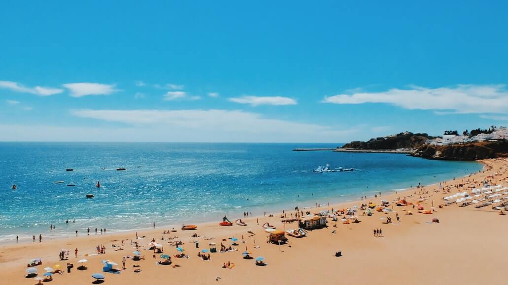 Beach image - tourists on a sandy shore by the sea