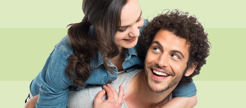 A healthy-looking couple smiling against a green background