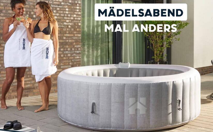 Frauen in Bikini und Handtuch posieren neben einem Home Deluxe Whirlpool