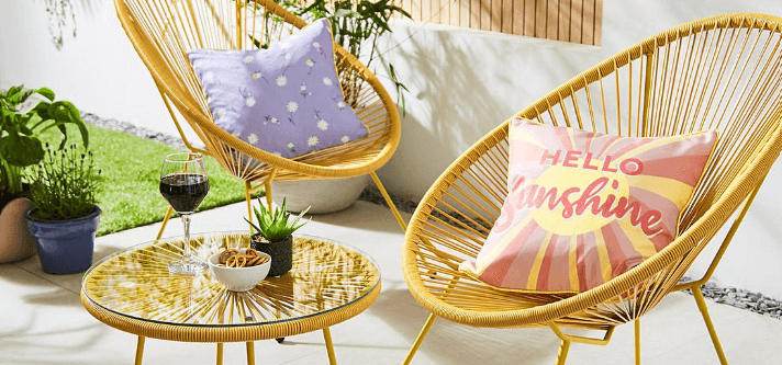 Home Essentials summer savings banner featuring an outdoor rattan furniture set with bright cushions