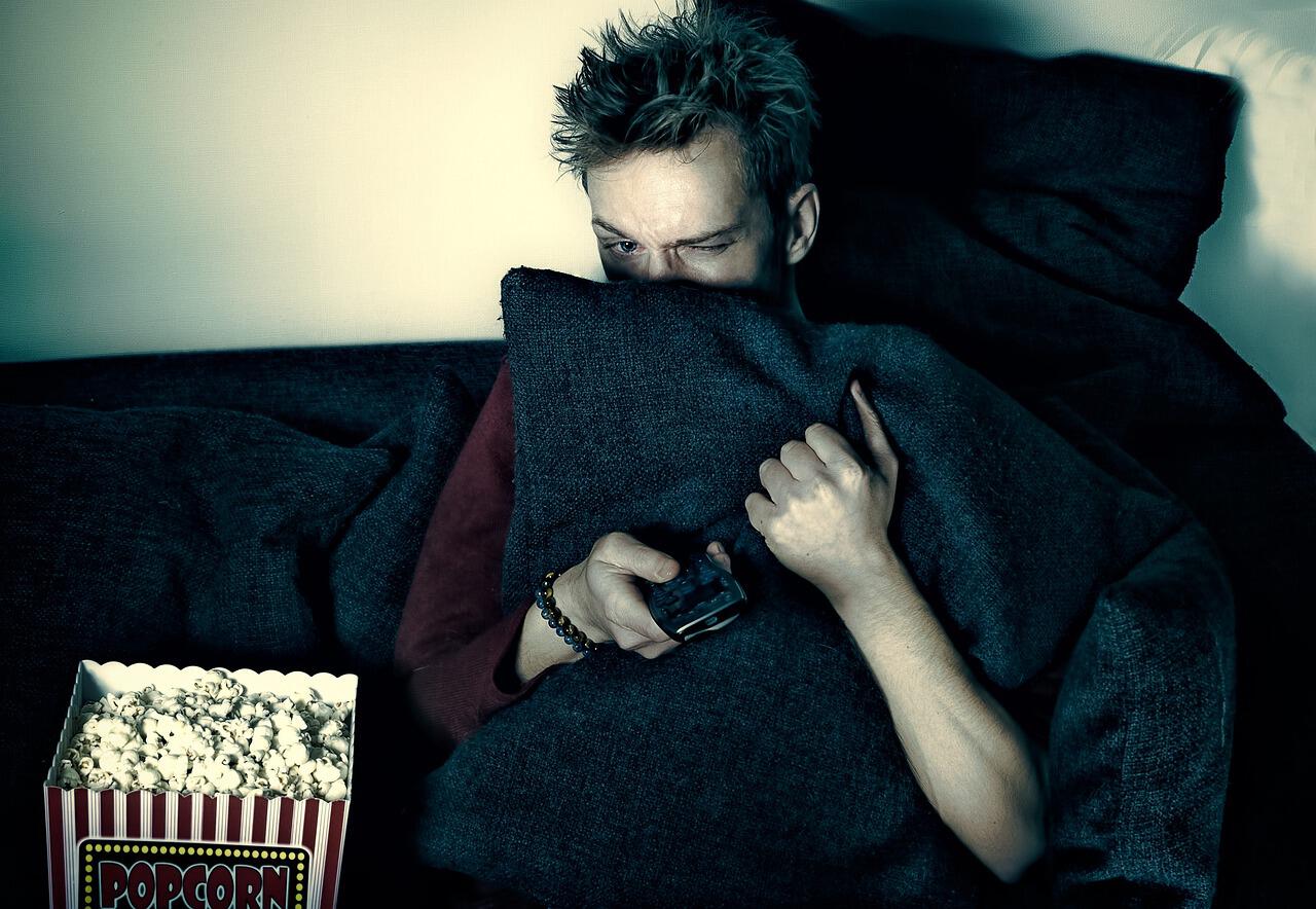 Homme qui a peur devant un film d&apos;Halloween