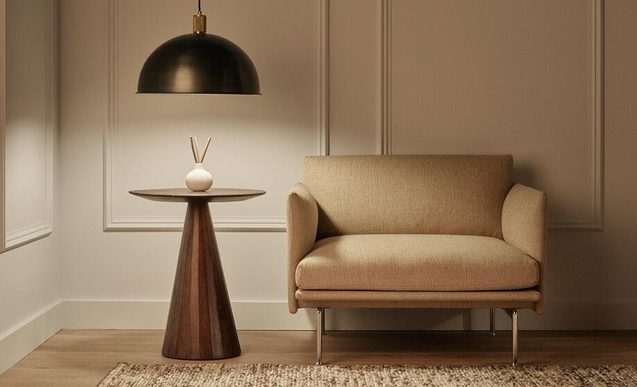Industville savings page image - Cream chair next to a stylish side table with mood lighting overhead