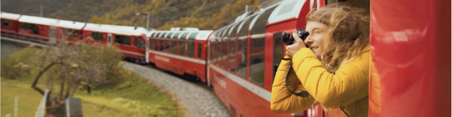 Banner für die Interrail Gutscheinseite mit Foto einer Person, die aus einem fahrenden Zug heraus fotografiert