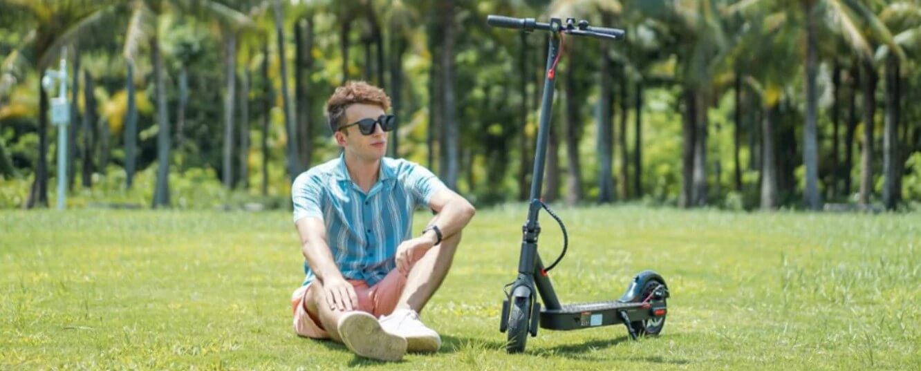 iScooter man sitting next to a scooter