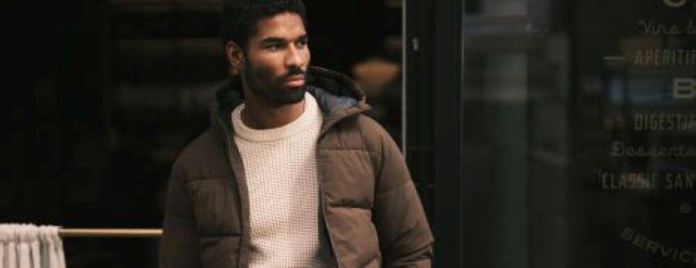 Jacamo fashion image - man wearing a brown padded jacket in front of a window