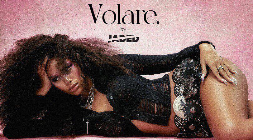 Banner der Jaded London Gutscheinseite: Frau liegt in Cropped Bluse und Rock aus kreisförmigen Lederpartien vor rosa Hintergrund; "Volare. by Jaded" Aufschrift
