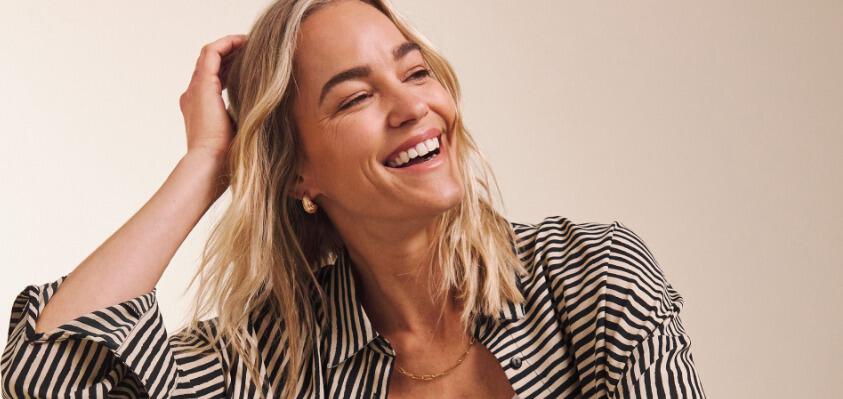 JD Williams fashion banner showing a woman laughing in a black and white stripe top