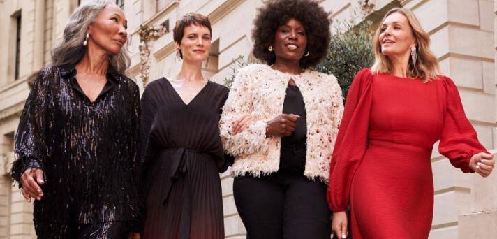 JD Williams offers page image showing four women walking done a street in party styles