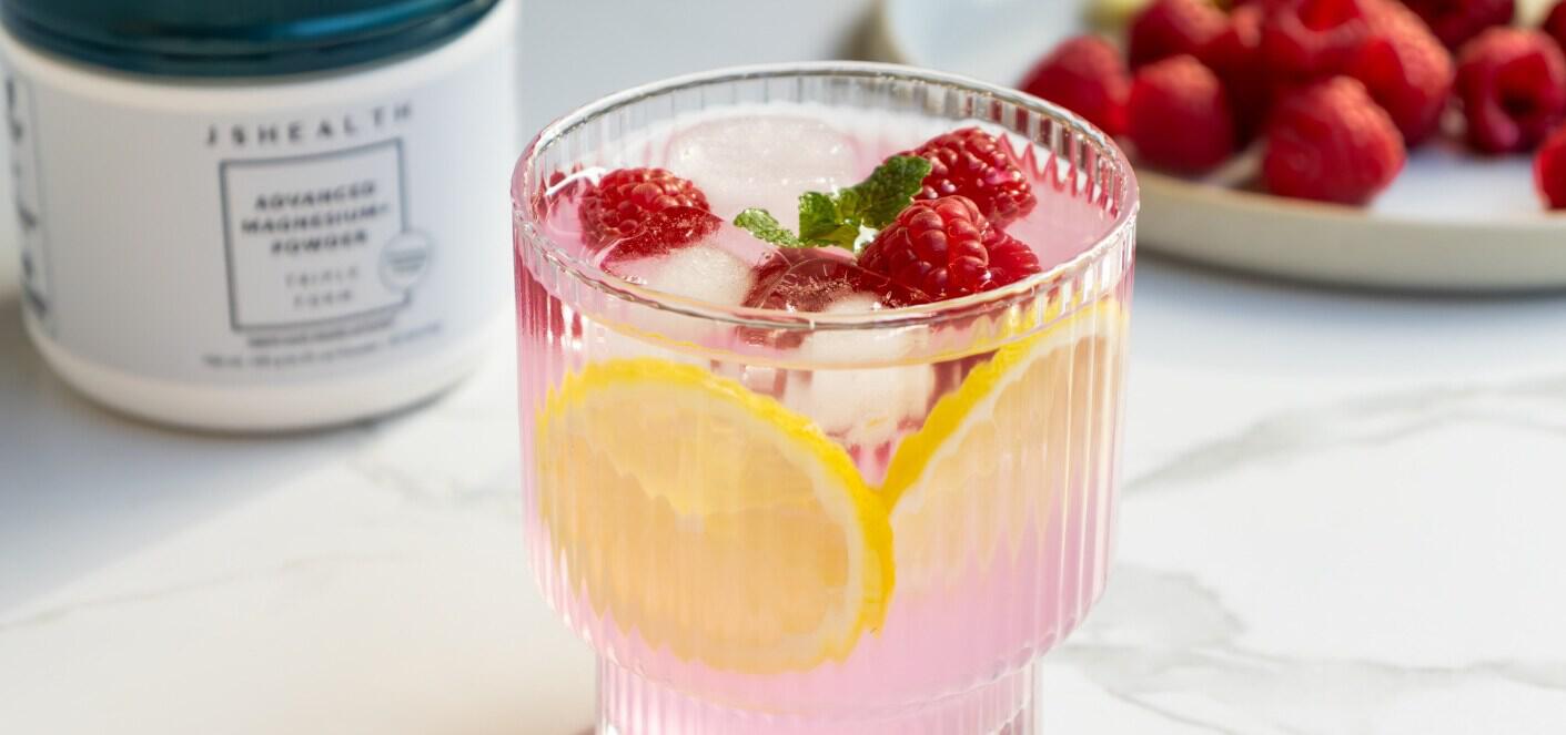 JSHealth Vitamins ways to save banner featuring a pink drink in a glass including raspberries and lemon slices