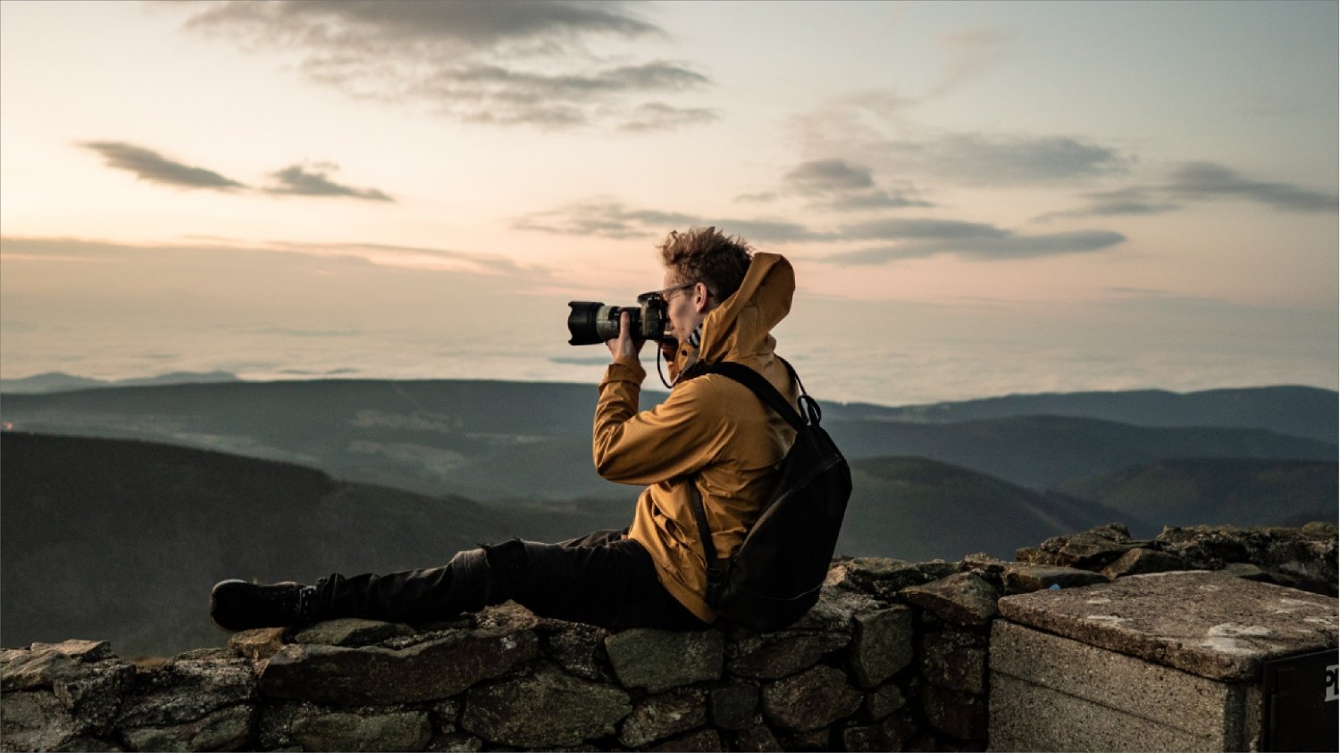 Hobby-Fotograf mit professioneller Kamera nimmt in den Bergen Fotos auf