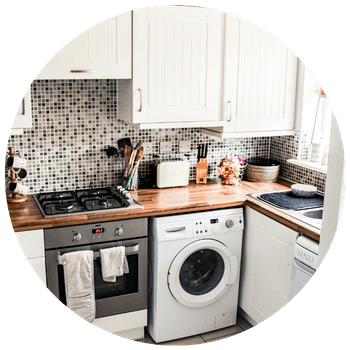 A kitchen featuring appliances like a washing machine, oven, and toaster.