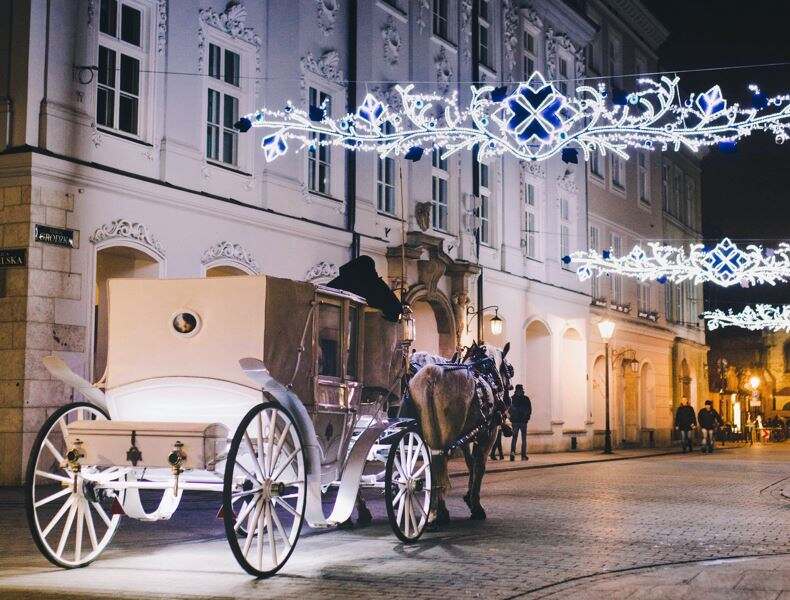 Kutsche in weihnachtlich geschmückter Straße in Krakau