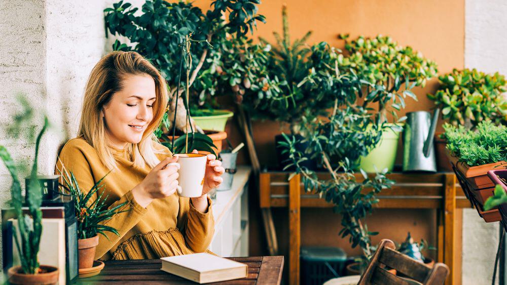 Woman enjoying a book and coffee on an outdoor patio