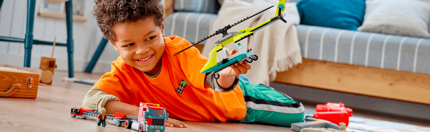 Kind hat einen LEGO Hubschrauber gebaut und spielt damit