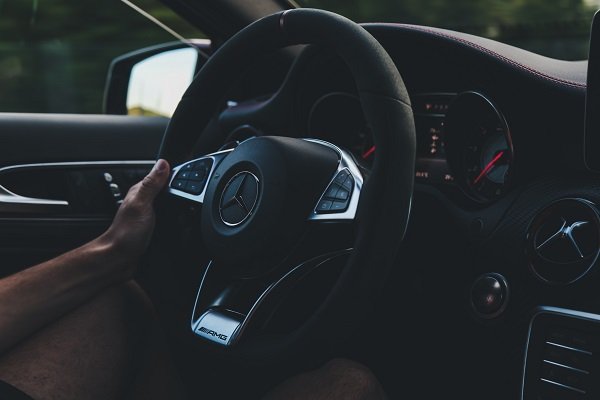 Hand an Lenkrad eines Mercedes Autos