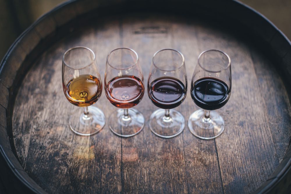 Quatre verres de vin posés sur un tonneau