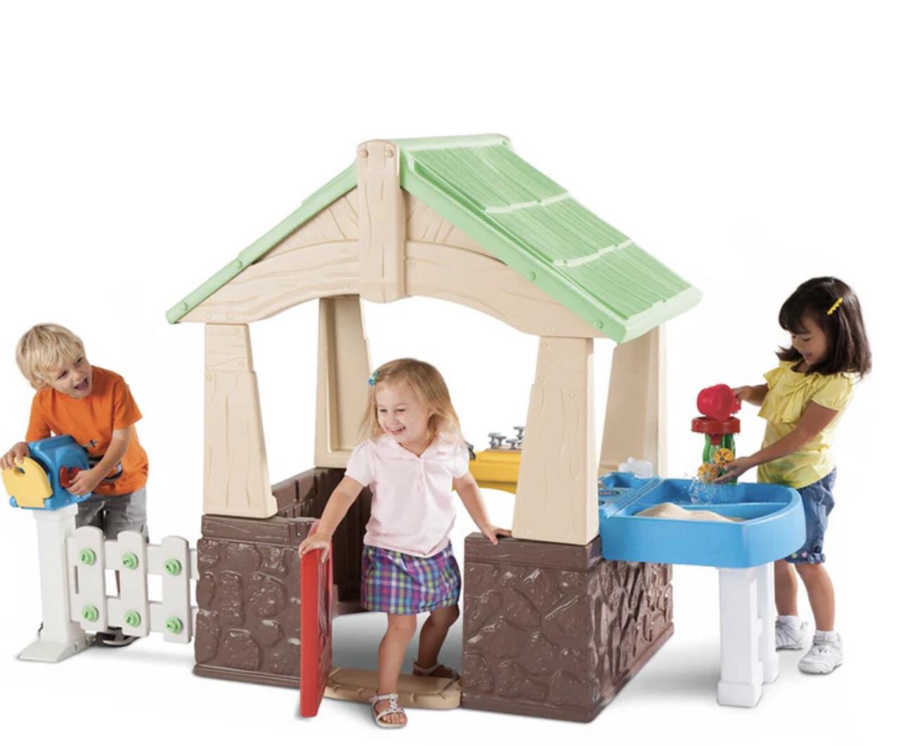 kids playing in front of little tikes playhouse