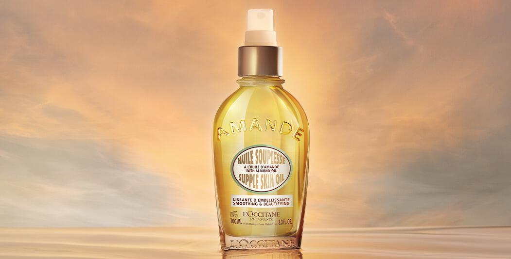 LOccitane savings image showing a bottle of Amande supple skin oil against a sky at dawn