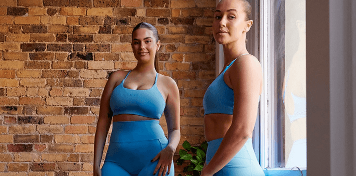 LSKD savings page banner featuring 2 women wearing blue activewear against the backdrop of a brick wall