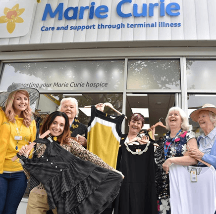 group of people outside a Marie Curie shop