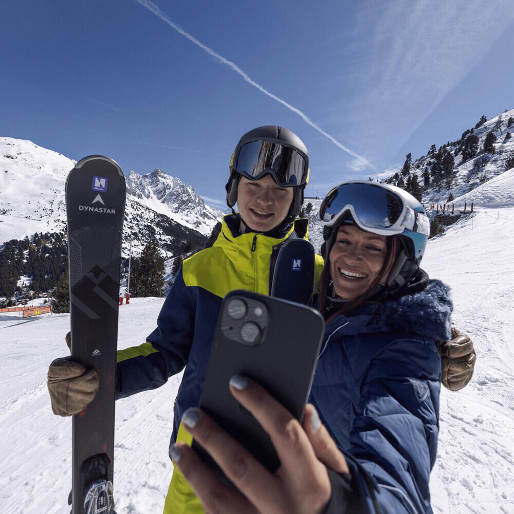 Two people taking selfie while snowboarding