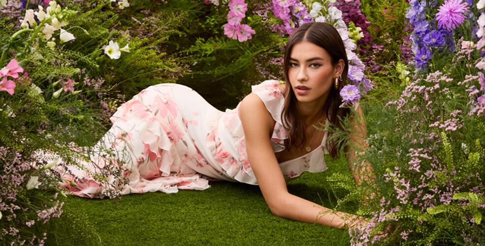 New Look savings image - A woman in floral dress lying among flowers and grass
