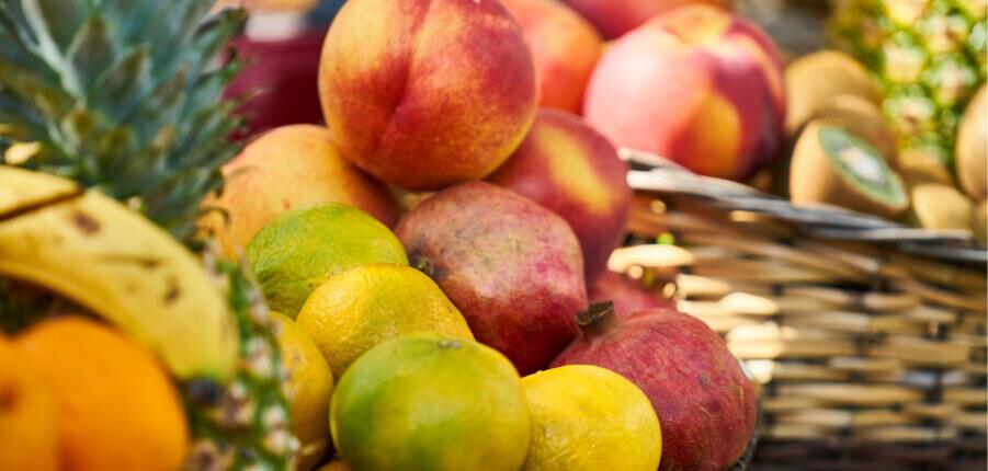 New year healthy eating image showing a selection of fruit including peaches and bananas, 901x430px