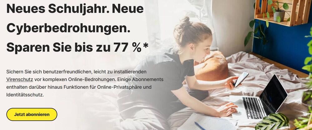 Bis zu 77 % Rabatt auf Norton Angebote zum Schulanfang – Mädchen auf Bett an Laptop mit Smartphone in einer Hand