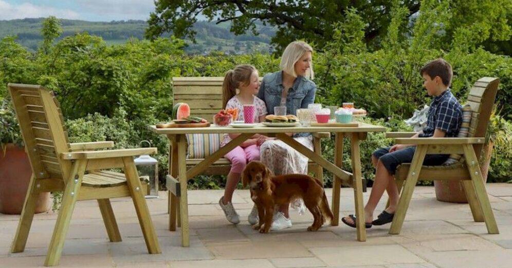 One Garden savings page banner - A woman, 2 kids and a dog sitting on garden furniture in front of a scenic view