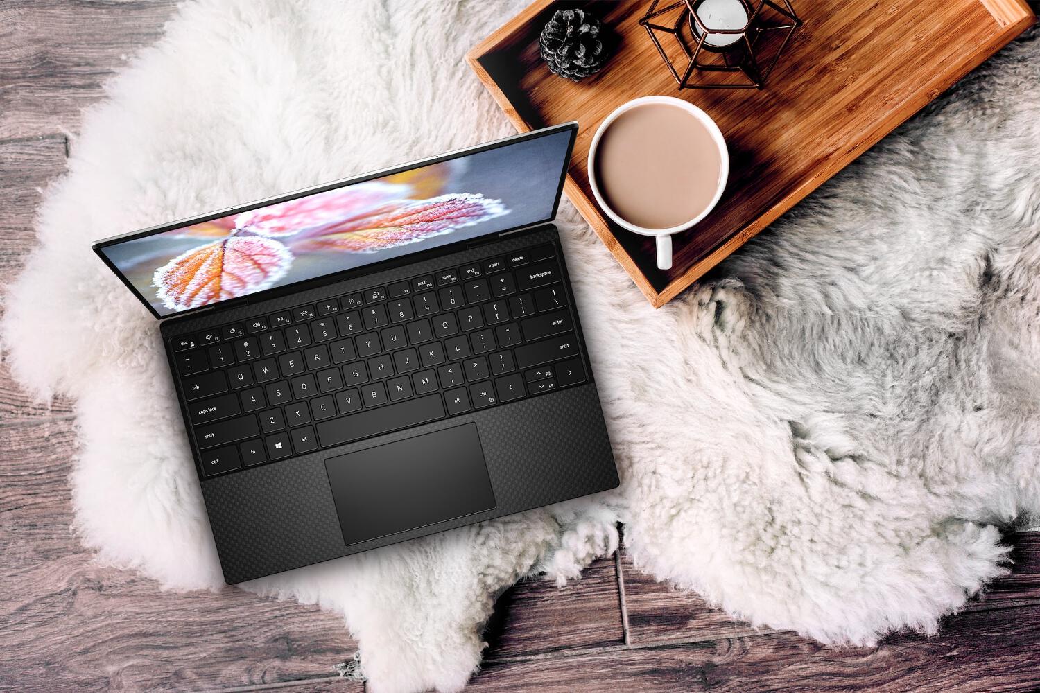 Ordinateur Dell XPS sur une couverture blanche à côté d'un plateau