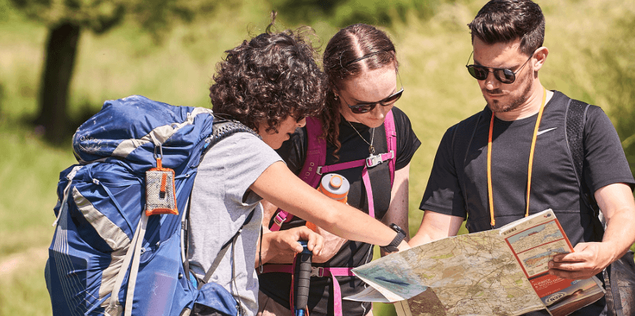 Ordnance Survey page image - Banner shows 3 people checking a map while hiking