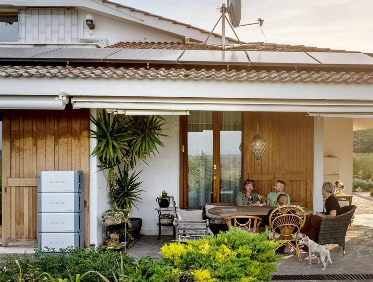 Famille devant une maison avec des panneaux solaires et une station énergie Bluetti