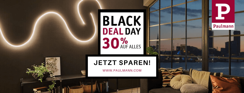 Paulmann Black Friday Rabatt 30 % auf alles – Foto eines gedimmt beleuchteten Wohnzimmers mit großer Fensterfront am Abend