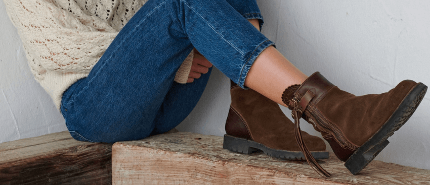 Penelope Chilvers savings guide banner. Image shows the bottom half of woman wearing brown boots while sitting on a wooden bench