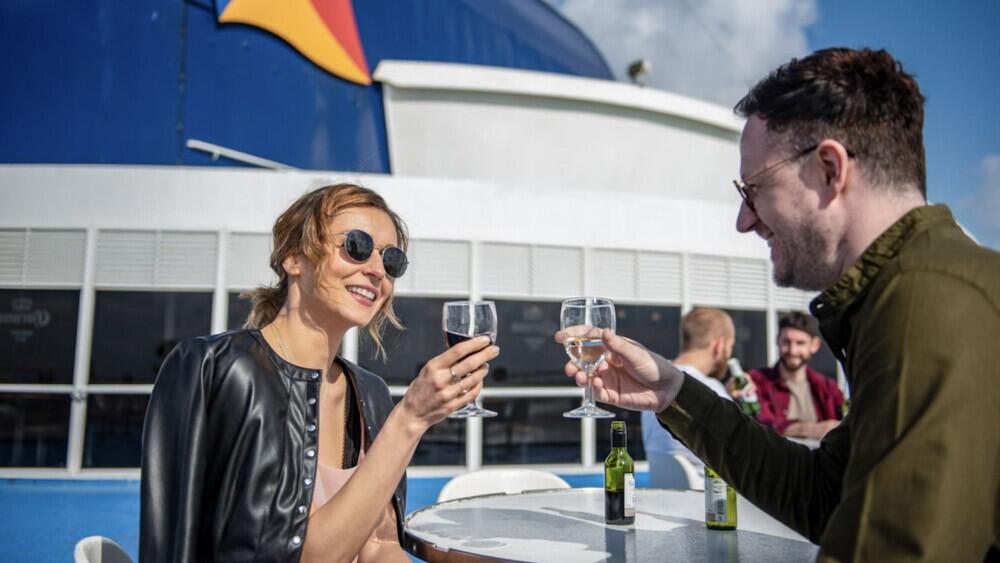 Mann und Frau stoßen an Bord bei einer P&O Ferries Fahrt an