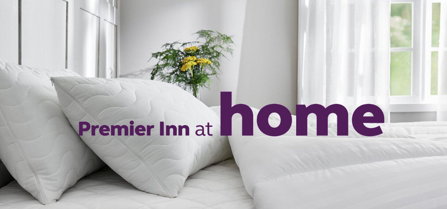 Premier Inn at Home savings banner showing white pillows and a duvet on a bed in bedroom setting. The company logo can be seen on top