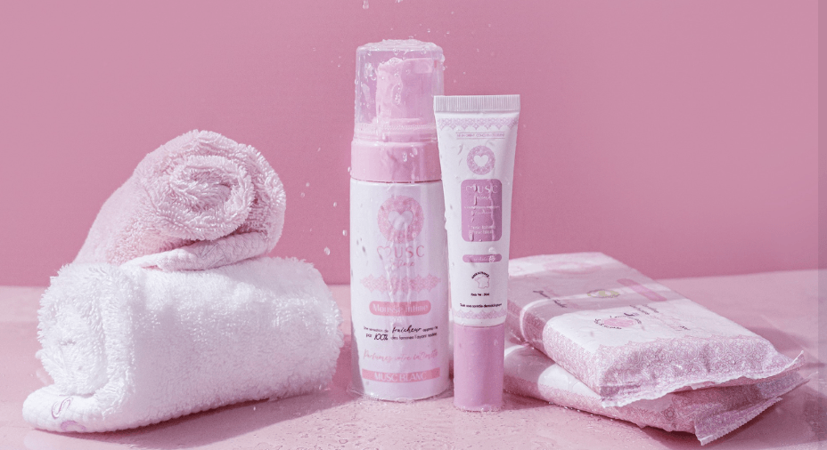 Des produits Musc Intime sur fond rose avec serviette