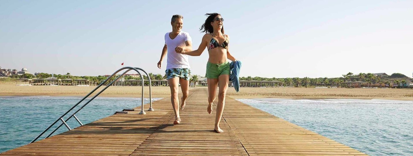 Paar läuft über einen Steg am Meer im Robinson Nobilis Resort in der Türkei